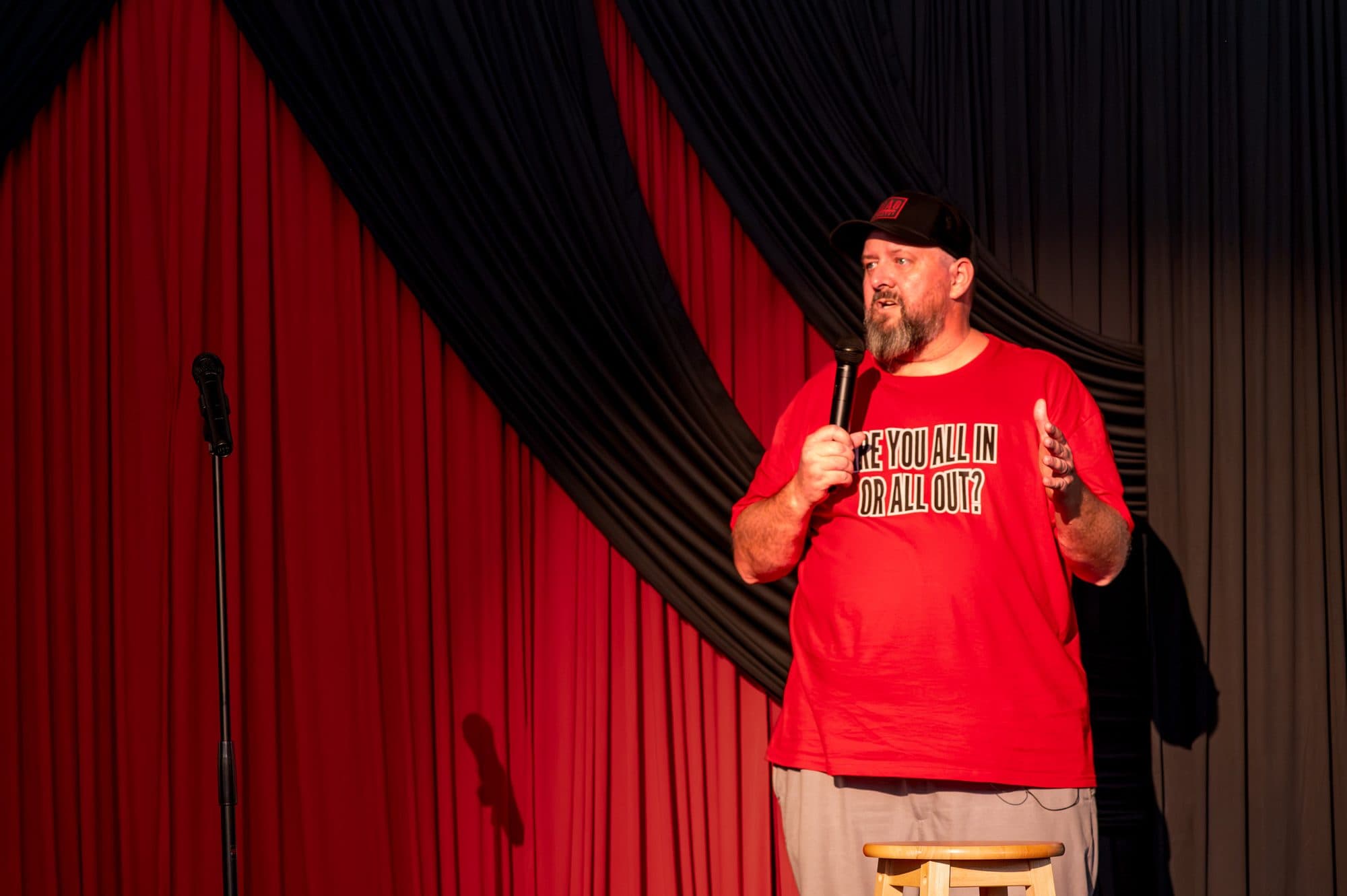 Speaker addressing the crowd at the Mic Drop Masters 2026 fundraiser.